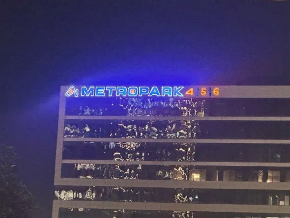 שלט מואר על גג בניין בלילה — METROPARK